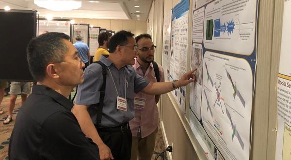 Jordan Cortez at 2019 SoCal Earthquake Center meeting A student and two faculty review a science poster presentation